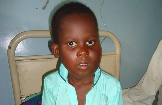 Young boy sitting in a hospital bed.
